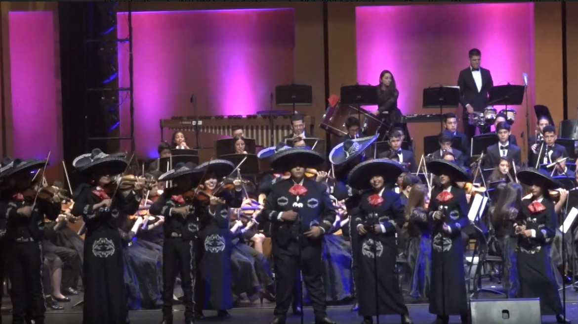 Mariachi y orquesta se fusionan para interpretar canciones tradicionales mexicanas.