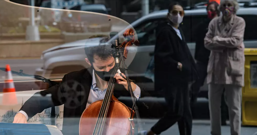 Hartos de la pandemia, músicos hacen de una vitrina en Nueva York su escenario