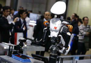 Visitors look at a Kawada Nextage robot at the International Robot Exhibition in Tokyo