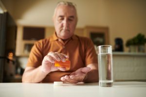 Serious Aged Man Taking Pills