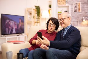 Old eldelry couple using a smartphone to talk with their family